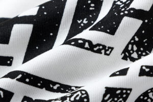 Close up view of the textured black and white graphic fabric print on the Hellstar Records Crazy Tee t-shirt design.