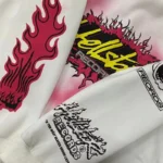 Close-up view of the white Hellstar Records hoodie featuring vibrant pink flame graphics and brand typography details.