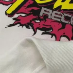 Close-up of the graphic screen print detail on the Hellstar Records White Hoodie with premium white fleece fabric.