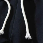 Close-up view of the adjustable white drawstring on the black Hellstar Red Flame sweatpants fabric.