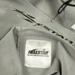 Detail of the gray Hellstar Shiesty balaclava ski mask featuring the brand logo and an NFC authentication label.