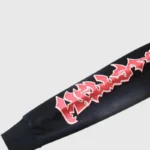 Hellstar Halloween skeleton airbrush tracksuit sleeve close-up with red Hellstar logo on black cuffed cotton sleeve