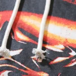 Close-up of the adjustable white drawstring on the black Hellstar Halloween Skeleton Airbrush Tracksuit hoodie.