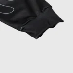 Close-up of the ribbed cuff and black fabric texture on the Hellstar Skull Drop Print Long Sleeve Tee.