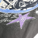 Close-up graphic detail of the Hellstar Skull Helmet T-Shirt featuring a stylized purple star and space theme print.