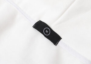 Close-up view of the white Hellstar Sport Hoodie size label showing a medium size tag on the interior fabric.