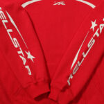 Red Hellstar Sport pullover hoodie featuring bold white reflective sleeve graphics and branding in a streetwear style.
