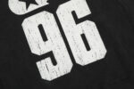 Close-up view of the white distressed 96 print on the front of a black Hellstar Sports crewneck sweatshirt.