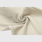 Close-up view of the premium heavyweight beige fleece fabric used for Hellstar Sports streetwear sweatpants.