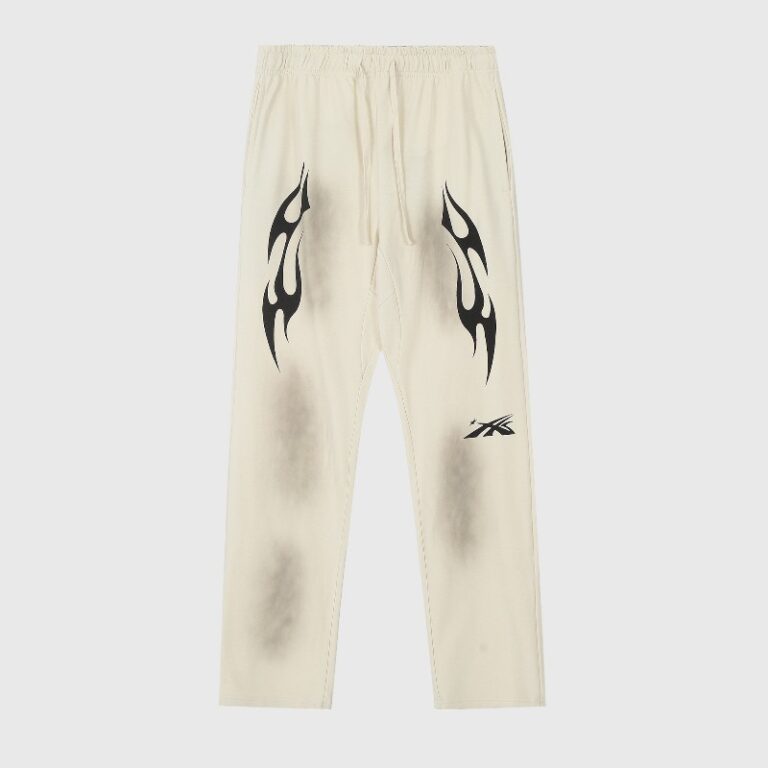 Hellstar Sports sweatpants in beige featuring black graphic flame prints and a vintage washed heavyweight fleece design.