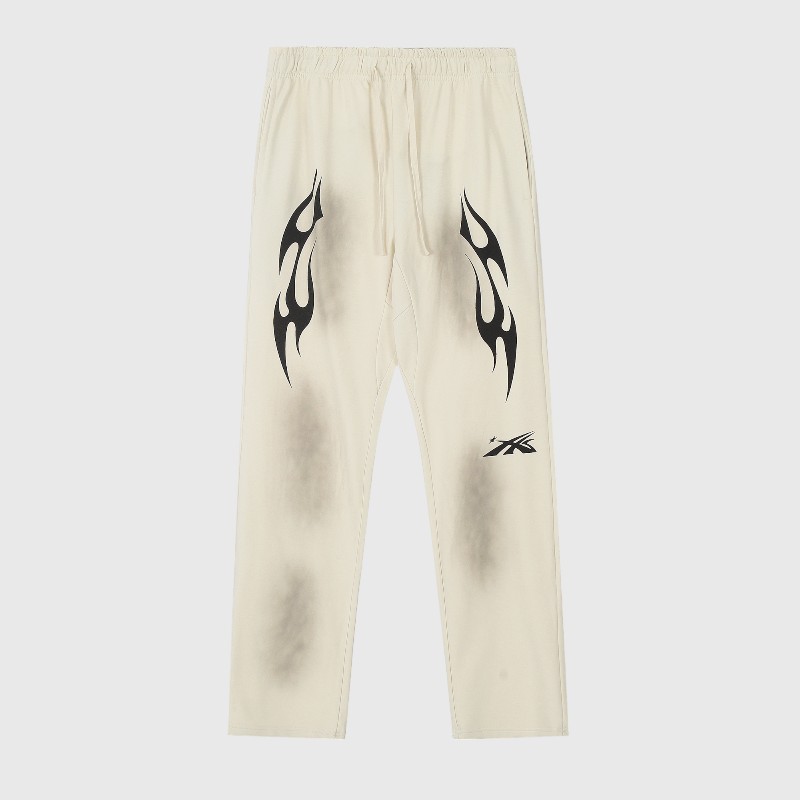 Hellstar Sports Beige Sweatpants Full View Hellstar Sports sweatpants in beige featuring black graphic flame prints and a vintage washed heavyweight fleece design.