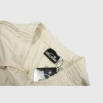 Close-up of the interior label and drawstring on a pair of vintage washed beige Hellstar Sports fleece sweatpants.