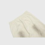 A close-up of the adjustable elastic waistband on the vintage washed beige Hellstar Sports fleece sweatpants.