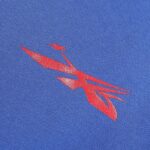 Close-up of the red Hellstar Sports gel logo graphic printed on blue cotton fleece fabric of a luxury tracksuit.