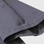 A close-up view showing the dark grey premium cotton fabric texture of the Hellstar Sports Core Logo T-Shirt.