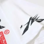 Close-up view of the unique distressed black and red graphic print details on a white Hellstar Sports Family T-shirt.