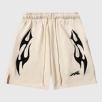 Hellstar Sports Flame shorts in beige featuring black cosmic flame graphics and a drawstring waist for a vintage look.