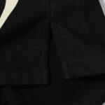 Close-up view of the side hem detail on black Hellstar Sports Flame shorts with reinforced stitching and soft fabric.