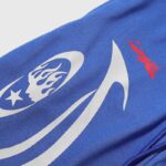 Close-up of the Hellstar Sports Gel blue sweatpants showing the iconic branding and star logo detail in white.