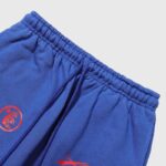 Close-up view of the adjustable drawstring waistband on the Hellstar Sports blue sweatpants with red graphic logos.