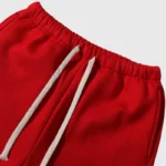 Close-up view of the elastic waistband and white drawstring on the red Hellstar Sports Gel performance sweatpants.