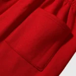 Close-up view of the convenient side pocket on the red Hellstar Sports Gel sweatpants, showcasing quality fabric.