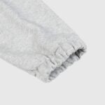 Close-up view of the ribbed cuff detail on the premium grey fabric of the Hellstar Sports grey crewneck sweater.