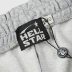 Close-up view of the Hellstar Sports grey sweatpant brand tag showing the signature logo on high-quality fleece fabric.