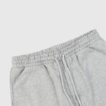 A detailed close-up showing the elastic waistband and drawstring detail of the premium Hellstar Sports grey sweatpants.