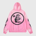 Back view of a pink Hellstar Sports zip-up hoodie featuring a black circular logo with star and flame graphics.
