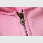 Close-up view of the premium metallic zipper closure on the pink Hellstar Studios streetwear zip-up hoodie.