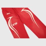 A pair of bright red Hellstar Sports sweatpants featuring white graphic side designs and a drawstring waist detail.