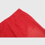 A close-up view showing the rear patch pocket and elastic waistband detail on the Hellstar Sports Red Sweatpants.