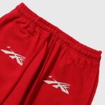 Red Hellstar Sports sweatpants featuring white branding and an elastic drawstring waist for a modern urban athletic look.