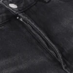 Close-up view of the button fly and metal hardware on premium black denim Hellstar Sports Star graphic jeans.