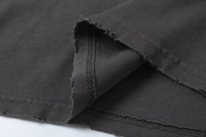 Close-up view of the black fabric and distressed raw edge hem detail of the Hellstar Sports Tee shirt.