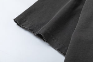 Close-up view of the raw-edge black sleeve detail on a premium 100% cotton Hellstar Sports vintage-washed T-shirt.