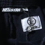 Close-up of a Hellstar Sports graphic tracksuit fabric featuring the official brand name tag and authentication label.