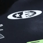 Close-up view of the bold white graphic print and signature logo on the Hellstar Sports black cotton tracksuit.