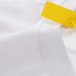 Close-up view of the premium 100% cotton fabric and stitching details on a white Hellstar Sports vintage t-shirt.