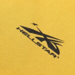 Close-up view of the bold black Hellstar sports logo graphic printed on high-quality yellow cotton fabric material.