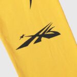 Close-up view of the yellow Hellstar Sports sweatpants fabric featuring a bold black graphic print design.