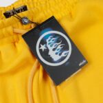 A close-up of the Hellstar Sports yellow sweatpant featuring the premium streetwear brand branding tag and emblem.