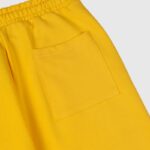 Close-up view of the rear pocket detail on the bright yellow heavyweight fleece Hellstar Sports sweatpants.