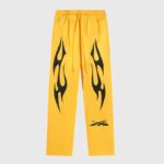 Front view of Hellstar Sports yellow sweatpants featuring black graphic flame prints and drawstring closure