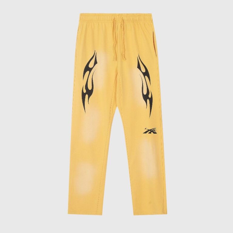 Front view of Hellstar Sports yellow sweatpants featuring a vintage wash finish, flame graphics, and a drawcord waistband.