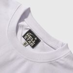 Close-up view of the interior neck tag on a white Hellstar Star T-shirt, proving the authenticity of the brand.