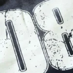 Close-up view of the unique distressed screen print graphic on the premium black Hellstar Studio logo shorts fabric.