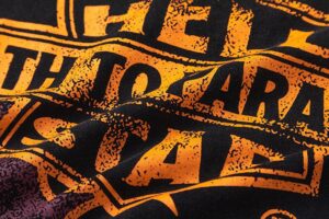Close-up view of the vintage-washed graphic screen print on the black Hellstar Studios Biker Tour T-shirt for men.