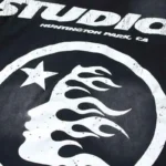 Close-up view of the Hellstar Studios Cartoon Logo graphic on a black vintage washed cotton crew neck t-shirt.